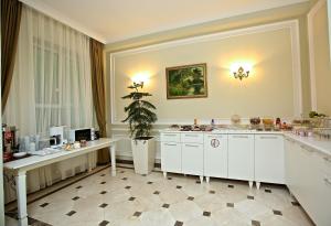 une cuisine avec des armoires blanches et une plante en pot dans l'établissement Miraj hotel, à Baku