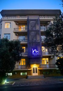 a building with a purple sign on the front of it at Miraj hotel in Baku