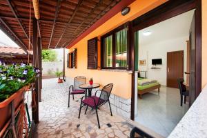 een patio met een tafel en stoelen en een slaapkamer bij Apartments Erik B&B Adults only in Rovinj