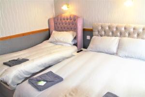 a pair of beds in a room with a headboard at Pine Lodge Hotel in Blackpool