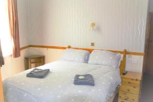 una camera da letto con un letto bianco con due asciugamani di Pine Lodge Hotel a Blackpool