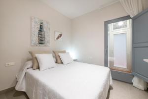 Un dormitorio blanco con una cama blanca y una ventana en Lovely & Cozy apartment in the heart of Banyoles en Banyoles