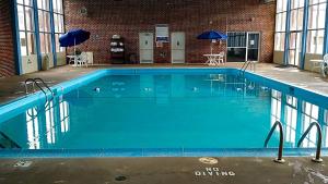 Norwood Inn & Suites La Crosse في لا كروس: مسبح كبير مع ماء ازرق في مبنى