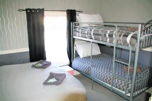 a bedroom with two bunk beds and a window at Pine Lodge Hotel in Blackpool