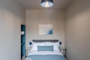 1 dormitorio con 1 cama con almohada azul en Swan House - Free Parking - Ten minute walk to train station - Perfectly located for City Centre & Racecourse en York