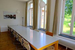a large conference room with a long table and chairs at Gutshaus Thorstorf FeWo Boltenhagen in Warnow