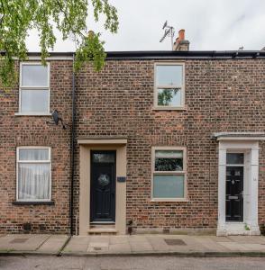 a brick house with a black door and windows at Swan House - Free Parking - Ten minute walk to train station - Perfectly located for City Centre & Racecourse in York