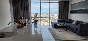 a living room with a blue couch and a large window at Durres City Apartment, City center & close to the beach in Durrës
