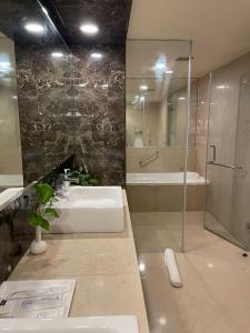 a bathroom with a sink and a shower and a tub at Paradigm Sarovar Portico in Kākināda