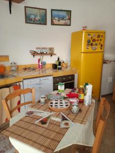 una cucina con tavolo e frigorifero giallo di La casina di Alicia a Montenero di Bisaccia
