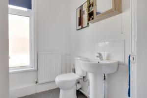 een witte badkamer met een toilet en een wastafel bij Stylish 3-Bedroom Oasis in Darlington, Sleeps 5 in Darlington