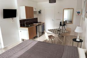 1 dormitorio con 1 cama y cocina con mesa en Studio indépendant 3 étoiles dans magnifique villa au bord du lac d'Annecy, en Veyrier-du-Lac