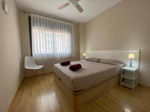 1 dormitorio con 1 cama, 1 silla y 1 ventana en Espectacular 4 pax con piscina a 250 m de la playa - LAVANDE PETIT en Lloret de Mar
