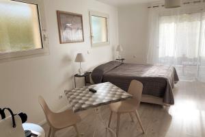 - une chambre avec un lit, une table et des chaises dans l'établissement Studio indépendant 3 étoiles dans magnifique villa au bord du lac d'Annecy, à Veyrier-du-Lac