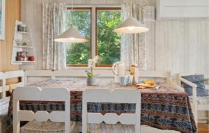 a kitchen with a table and chairs and a window at Nice Home In Or With House Sea View in Orø