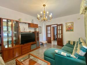 un salon avec un canapé bleu et une télévision dans l'établissement Casa Antigua Estacion By Solymar Holiday, à Malaga