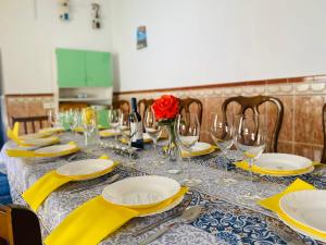 une table avec des serviettes et des verres jaunes et une rose rouge dans l'établissement Casa Antigua Estacion By Solymar Holiday, à Malaga