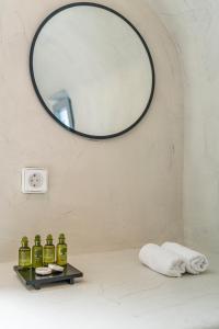 a bathroom with a mirror and a shelf with green bottles at Villa Paradeisos Karterados in Karterados