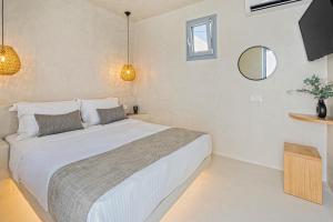a bedroom with a large bed and a mirror at Villa Paradeisos Karterados in Karterados