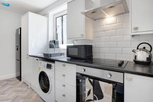 a kitchen with a washer and dryer on a counter at Inviting 2-Bedroom Home in Coxhoe, Sleeps 4 in Coxhoe