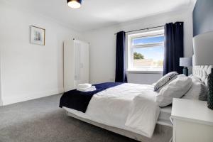 a white bedroom with a bed and a window at Inviting 2-Bedroom Home in Coxhoe, Sleeps 4 in Coxhoe