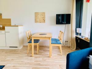 eine kleine Küche mit einem Tisch und Stühlen in einem Zimmer in der Unterkunft Ostseeschwalbe am Fahrenkrog in Sierksdorf