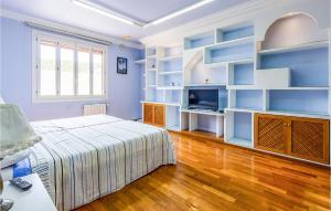 1 dormitorio con paredes azules, 1 cama y TV en Lovely Home In Elche With Kitchenette, en Elche