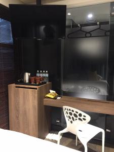 Zimmer mit einem Schreibtisch, einem Stuhl und einem Bett in der Unterkunft Chez Taipei No 5 in Taipeh