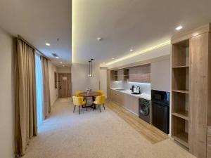 eine Küche und ein Esszimmer mit einem Tisch und gelben Stühlen in der Unterkunft Apart Hotel Istaravshan in Taschkent