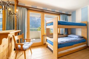 a bedroom with bunk beds and a desk and a chair at Au Reduit 106 in St. Moritz