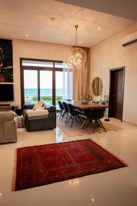 ein Wohnzimmer mit einem Tisch und einem Esszimmer in der Unterkunft Night Moon Villa JEBEL SIFA ,BF-109 in Muscat