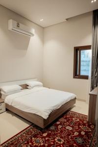 a white bedroom with a bed and a window at Night Moon Villa JEBEL SIFA ,BF-109 in Muscat