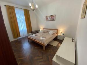 a bedroom with a bed and two windows at Apartman Anđela Pula Centar in Pula
