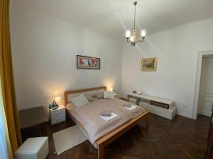 a small bedroom with a bed and a chandelier at Apartman Anđela Pula Centar in Pula
