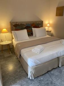 a bedroom with a large bed with two towels on it at Aelia Houses in Agia Marina Aegina