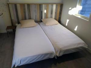 1 cama grande con 2 sábanas y almohadas blancas en Studio 26, en Vic-le-Comte