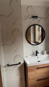 a bathroom with a sink and a mirror at Domek Bogusza in Kamionka Wielka