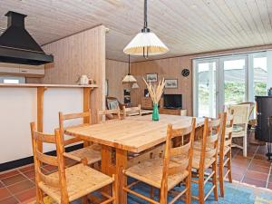 ヴィデ・サンデにある5 person holiday home in Hvide Sandeのキッチン、ダイニングルーム(木製のテーブルと椅子付)