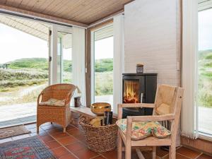 a screened in porch with a fireplace and chairs at 5 person holiday home in Hvide Sande in Hvide Sande