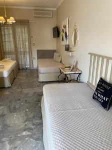 1 dormitorio con 2 camas y mesa con ordenador portátil en Aelia Houses en Agia Marina Aegina