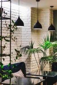 a room with two potted plants and pendant lights at Hotel Alpha in Sarandë
