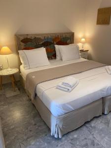 1 dormitorio con 1 cama grande y 2 toallas. en Aelia Houses, en Agia Marina Aegina