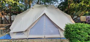 a large tent in a yard with a bush at Magic Garden Emperor Bell Tent in Vama Veche