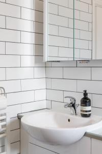 een witte badkamer met een wastafel en een spiegel bij Beachfront Getaway 2-Bedroom House with FREE Private Parking & Patio in Brighton & Hove
