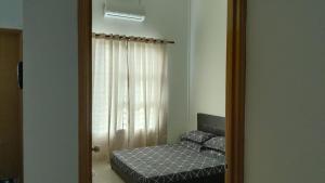 a small bedroom with a bed and a mirror at 42 Avenue Homestay Samarahan in Kota Samarahan
