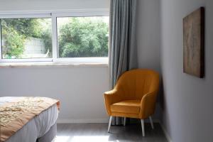 Arneiro的住宿－竹林书屋，卧室设有靠窗的椅子