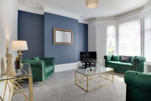 a living room with blue walls and green furniture at Stunning 4-Bedroom, 2 Bathrooms in Sunderland in Sunderland