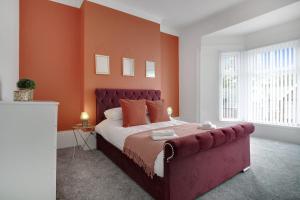 1 dormitorio con 1 cama grande y paredes de color naranja en Stunning 4-Bedroom, 2 Bathrooms in Sunderland en Sunderland