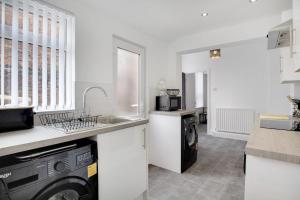 eine Küche mit Spüle und Waschmaschine in der Unterkunft Stunning 4-Bedroom, 2 Bathrooms in Sunderland in Sunderland + 24 Fotos