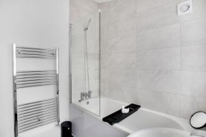 baño blanco con ducha y lavamanos en Stunning 4-Bedroom, 2 Bathrooms in Sunderland en Sunderland